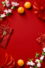 Wall Mural - Chinese New Year 2023 composition. Top view frame of red pockets, flowers, oranges on red background.