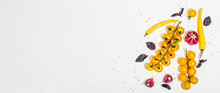 Culinary Background With Ripe Vegetables. Yellow Tomato Cherries, Chili Pepper, Garlic, Purple Basil. Fresh Vegetables On White Putty Background, Modern Hard Light, Dark Shadow, Flat Lay