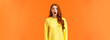 Shocked redhead cute girl drop jaw astounded and speechless, stare camera popped eyes, cant believe, standing impressed and fascinated, losing speech over orange background