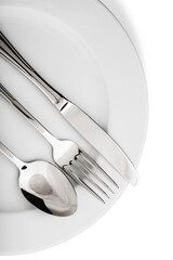 Silver knife, spoon and fork on a white plate