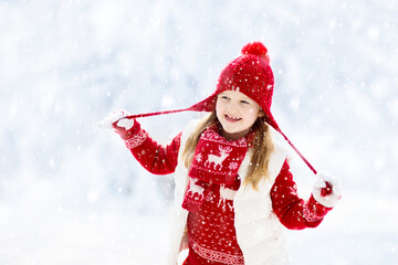 Child playing in snow on Christmas. Kids in winter