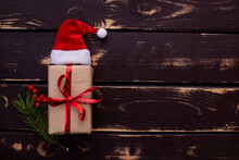 Christmass Flatlay Gift Box,Santa Hat And Christmas Spruce Branch On Wooden Background.