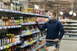 © Alexander - A man in a protective face mask chooses food in the store. Food and drinks. Safety