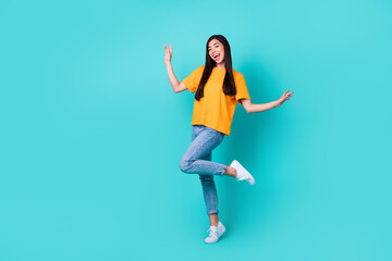 Wall Mural - Full body photo of cute brunette lady dance wear orange t-shirt jeans shoes isolated on teal color background