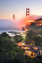 A foggy sunset behind the Point Cavallo hotel, at the Golden Gate Bridge.