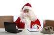 © alphaspirit - santa claus works in office with laptop and phone