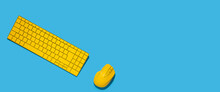 Yellow Keyboard And Yellow Computer Mouse On A Blue Background. Top View, Flat Lay. Banner
