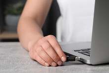 Woman Attaching Usb Flash Drive Into Laptop At Light Grey Table, Closeup