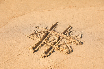 Canvas Print - Tic tac toe game drawn on sandy beach