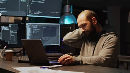 Database programer writing code and dealing with back pain, sitting at office and feeling spinal discomfort at night. App developer computing big data and coding html script on terminal window.