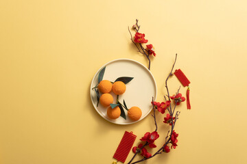 Wall Mural - Chinese new year holiday background stylish with tangerine, Blossom, mandarin orange, and lucky ornaments. Empty space for text