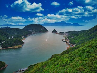 Sticker - Beautiful view of lush green trees and mountains overlooking a lone boat near Unzen in Kyushu, Japan