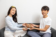 © bennnn - Asian teen boy and girl exchange a gift box, Happy and smiling sit on a sofa at home.
