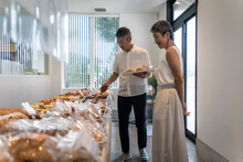 パン屋でパンを選ぶ日本人シニア夫婦