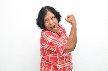 Portrait of happy ecstatic senior asian woman making yes winning gesture with raising her fist isolated over white