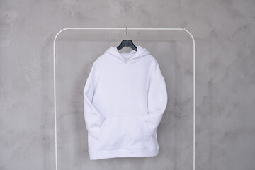 Wall Mural - A set of mockups of a white hoodie with a hood and a pocket hanging on a hanger