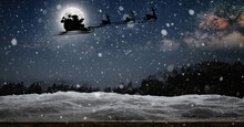 Santa Claus Flies On Christmas Eve In The Night Sky With Snow