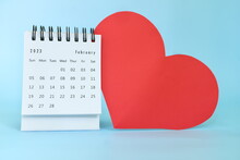 Selective Focus Of February 2023 Desk Calendar With Big Red Heart Shape On Blue Background With Copy Space.