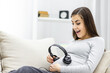 © Andrii - Photo of lovely pregnant woman with headphones.