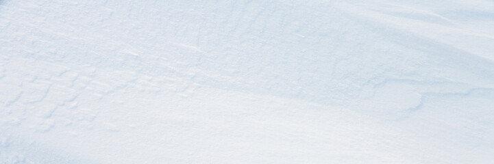 Wall Mural - Beautiful winter background with snowy ground. Natural snow texture. Wind sculpted patterns on snow surface. Wide panoramic texture for background and design.