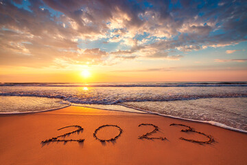 Happy New Year 2023 ocean sunrise on the beach shore concept