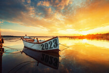 2023 Happy New Year Concept. Fishing Boat On Varna Lake With A Reflection In The Water At Sunset. Nature Landscape.