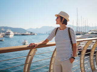 Wall Mural - Marmaris is resort town on Turkish Riviera, also known as Turquoise Coast. Marmaris is great place for sailing and diving. Asian woman with hat walking on pier in harbor.