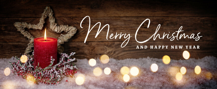 Fototapete - Christmas Greeting Card with English text Merry Christmas and Happy New Year. Panorama, Banner. Christmas candle in winter snow landscape with magic lights. Xmas Wood background with copy space.
