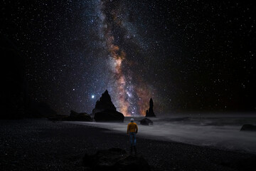 Wall Mural - man observing the stars from a beach in iceland
