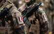 © Dragoș Asaftei - France Army soldiers uniform. Close up photo with the France flag on a military soldier uniform with the gun next to it. Military industry concept photo.