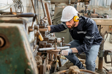 Team of engineers practicing maintenance Taking care and practicing maintenance of old machines in the factory so that they can be used continuously.