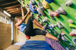 © ADDICTIVE STOCK - Female climber hanging on tilted wall