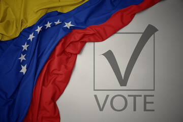 waving colorful national flag of venezuela on a gray background with text vote. 3D illustration