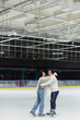 © LIGHTFIELD STUDIOS - Side view of cheerful african american woman embracing boyfriend on ice rink