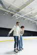 © LIGHTFIELD STUDIOS - Smiling african american woman ice skating with boyfriend on rink
