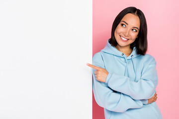 Poster - Photo of shiny dreamy girl dressed blue sweatshirt looking pointing blank board empty space isolated pink color background