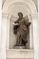 Sculpture saint Peter on wall catholic cathedral in old history town Lutsk. Statue religion christian in arch on ancient facade. Ukrainian architecture and culture monument. Mediaeval roman catholic.