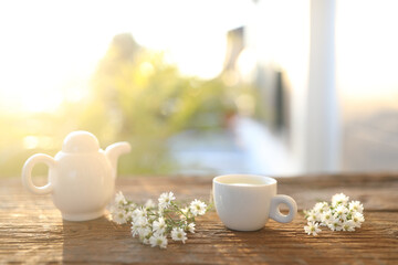 Wall Mural - Tea cup and tea pot and aster flowers on wooden table