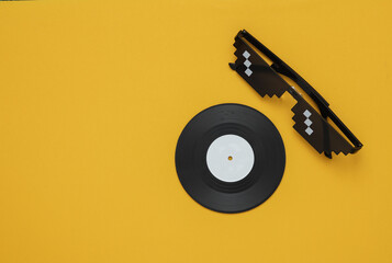 Poster - Stereo headphones with vinyl record on yellow background. Music concept