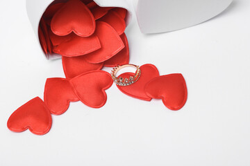 Wall Mural - Gift box with red hearts and a golden ring in the form of a crown on a white background. Romantic gift