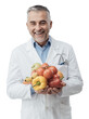© stokkete - Smiling nutritionist holding fresh vegetables and fruit