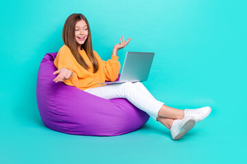 Sticker - Full length photo of pretty funky school girl dressed orange hoodie bean bag talking device empty space isolated teal color background