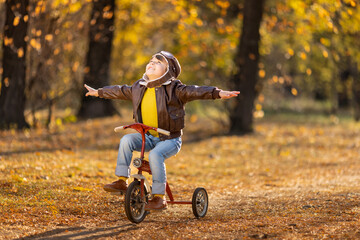 Wall Mural - Happy child having fun outdoor in autumn park