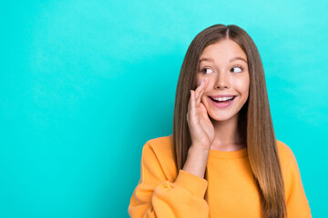 Wall Mural - Photo of young funny cute pretty teenager girl wear orange sweatshirt speak silent rumor looking empty space secret isolated on cyan color background