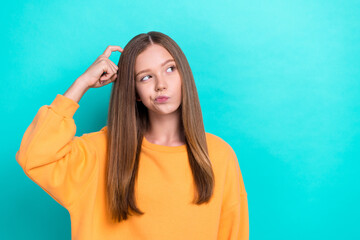 Wall Mural - Closeup portrait of young beautiful girl scratch head minded looking empty space pouted lips hmm hard choice isolated on cyan color background