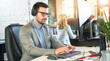 © Bojan - Male call centre agent with headset working on computer in office.