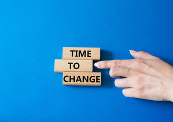 Time to change symbol. Concept word Time to change on wooden blocks. Businessman hand. Beautiful blue background. Business and Time to change concept. Copy space