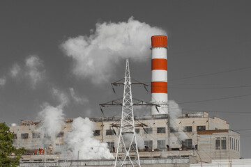 Wall Mural - The pipe of the industrial plant emits toxic grey smoke into the atmosphere sky and air. Pollution of the environment and ecology. Thermal power plant power lines high voltage