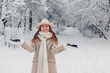 © maryviolet - Happy fashionable young woman tossing snow up in frosty winter park wearing stylish warm clothes and having fun.