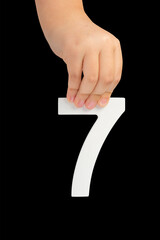 Aufkleber - Number seven in hand isolated on black background. Number 7 in a child's hand on a black background. To be inserted into a project or design.